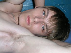 Dark-haired twink with piercing eyes showing his feet
