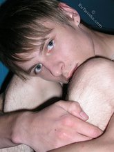 Dark-haired twink with piercing eyes showing his feet