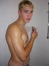 Blond-haired twink showering and looking seductive