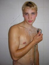 Blond-haired twink showering and looking seductive