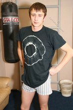 Shy-looking young twink waves goodbye to the camera