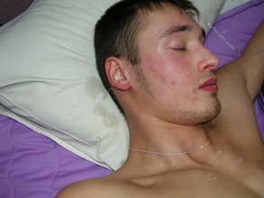 Two guys jerking off next to each other on a bed
