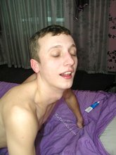 Two dudes make out with each other on a bed
