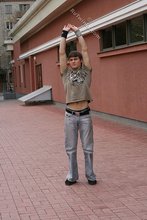 Athletic dude in oversized jeans is doing handstands outdoors