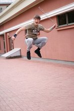 Athletic dude in oversized jeans is doing handstands outdoors
