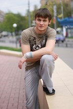 Athletic dude in oversized jeans is doing handstands outdoors