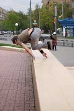 Athletic dude in oversized jeans is doing handstands outdoors