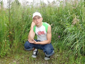 Baseball cap and jorts-wearing twink posing outdoors