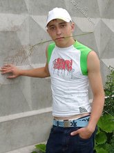 Baseball cap and jorts-wearing twink posing outdoors