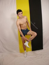 Dark-haired young boy taking his sexy jeans off