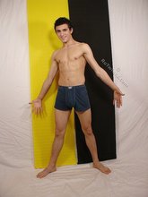 Dark-haired young boy taking his sexy jeans off