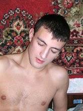 Dark-haired stud with a slim body masturbating on a couch