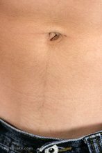 Dark-haired guy flaunting his six pack on camera