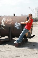 Jacked-up young boy showing his abs on the roof