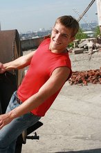 Jacked-up young boy showing his abs on the roof
