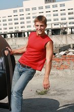 Jacked-up young boy showing his abs on the roof