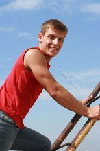 Jacked-up young boy showing his abs on the roof