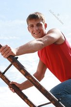 Jacked-up young boy showing his abs on the roof