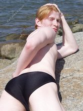 Redheaded twink posing in his sexy shades on a beach