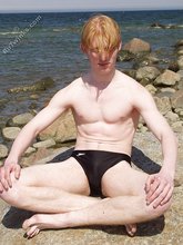 Redheaded twink posing in his sexy shades on a beach