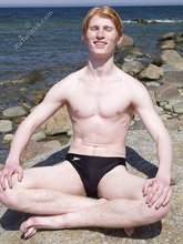 Redheaded twink posing in his sexy shades on a beach
