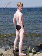 Redheaded twink posing in his sexy shades on a beach