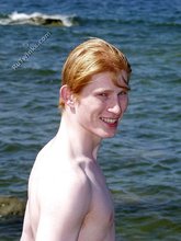 Redheaded twink posing in his sexy shades on a beach