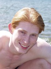 Redheaded twink posing in his sexy shades on a beach