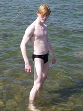 Redheaded twink posing in his sexy shades on a beach