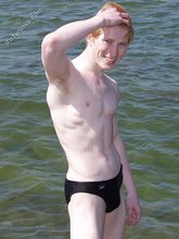 Redheaded twink posing in his sexy shades on a beach