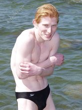 Redheaded twink posing in his sexy shades on a beach