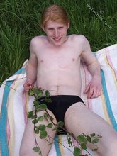 Redheaded twink posing in his sexy shades on a beach