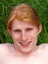 Redheaded twink posing in his sexy shades on a beach