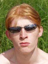 Redheaded twink posing in his sexy shades on a beach