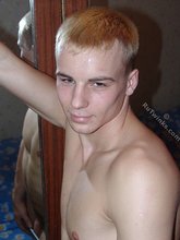 Blond-haired twink shows his meaty junk on a bed