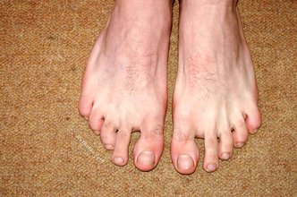 Curly-haired twink flashing his sexy feet and his cock