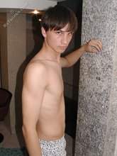 Twink with dark hair striking suggestive poses
