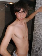 Twink with dark hair striking suggestive poses