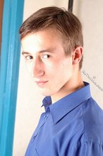 Serious-looking young boy starts undressing on cam