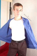 Serious-looking young boy starts undressing on cam