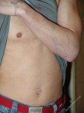 Pouty dark-haired guy shows his sexy arms and abs