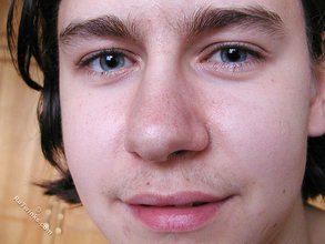 Blue-eyed brunette twink posing naked in his room