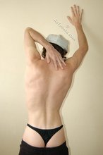 Curly-haired young boy wearing the sluttiest thong