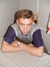Blond-haired boy posing shirtless in his camo pants