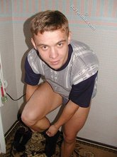 Blond-haired boy posing shirtless in his camo pants