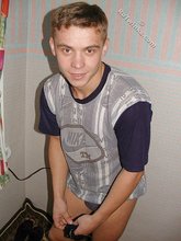 Blond-haired boy posing shirtless in his camo pants