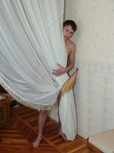 Tatted-up twink posing with his naked ass by the wall