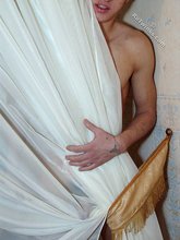Tatted-up twink posing with his naked ass by the wall