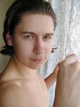 Twink with slicked back hair stripping on camera