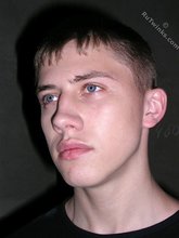 Blue-eyed buff twink posing shirtless and looking smart